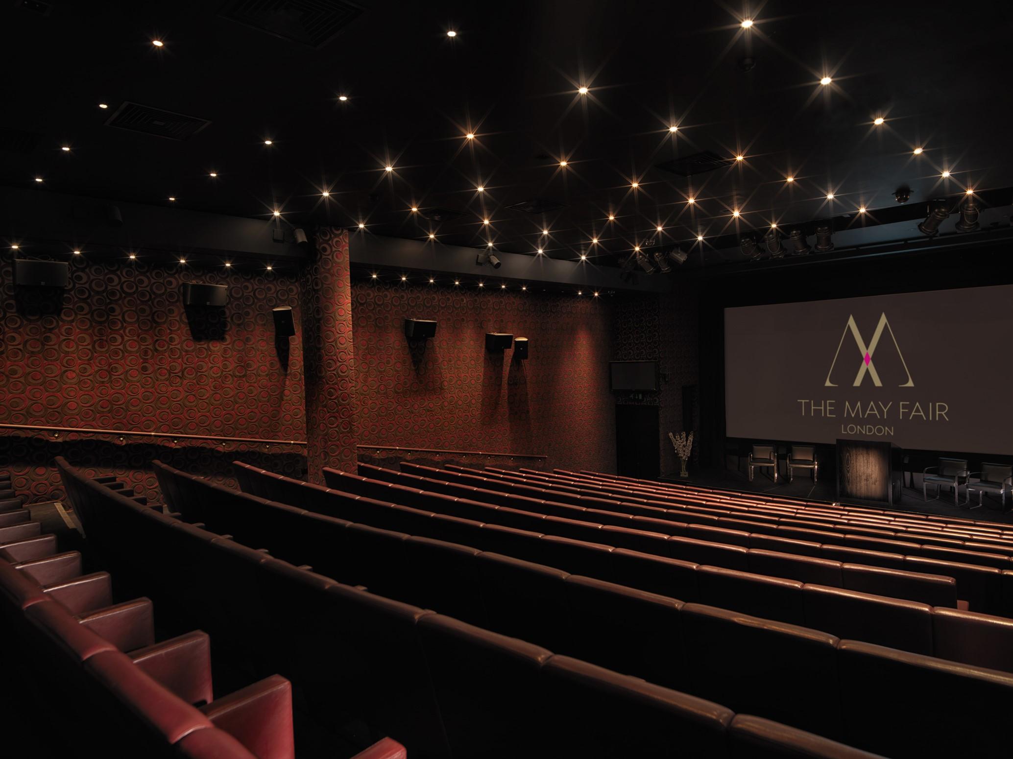 The May Fair, A Radisson Collection Hotel, Mayfair Londra Esterno foto The photo shows the interior of a movie theater named "The May Fair." The venue features a spacious auditorium with dark, plush seating arranged in rows facing a large screen at the front. The walls are brick, and the ceiling is adorned with numerous