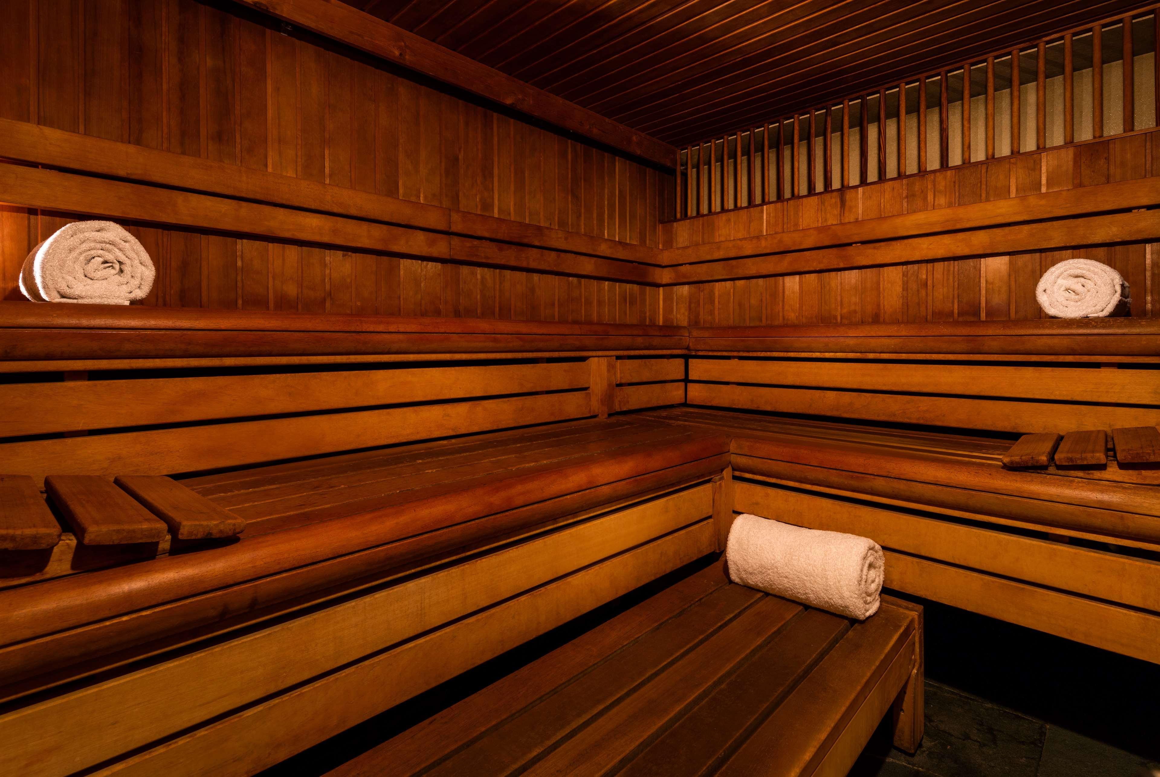 The May Fair, A Radisson Collection Hotel, Mayfair Londra Esterno foto The photo shows the interior of a sauna. It features wooden benches arranged along the walls, providing seating for visitors. There are neatly rolled white towels placed on the benches, giving a clean and inviting appearance. The walls and ceiling ar